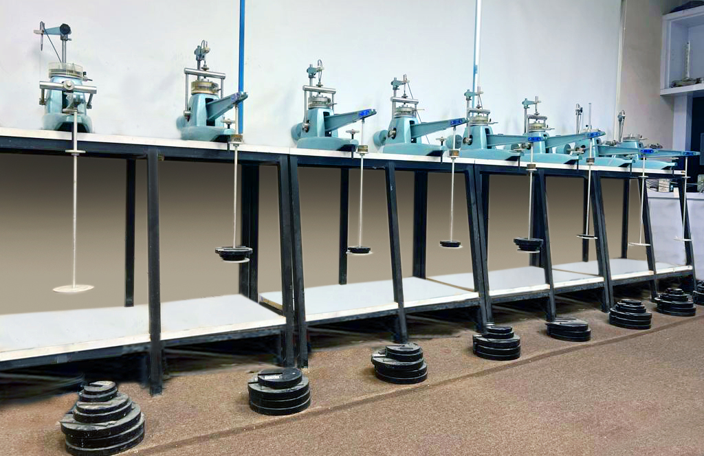 A row of soil consolidation test frames with applied weights